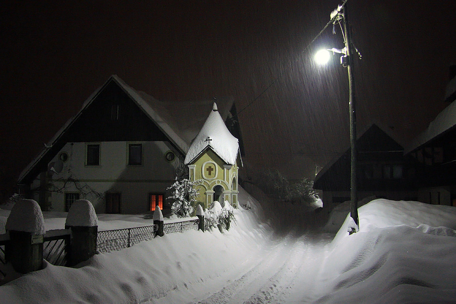 Ta prava zima II.
Podobna kot predhodna slika, tu ni bil uporabljen fleš in je sneženje vidno le ob ulični svetilki. 
Ključne besede: zima ulica bohinj bohinjska bistrica