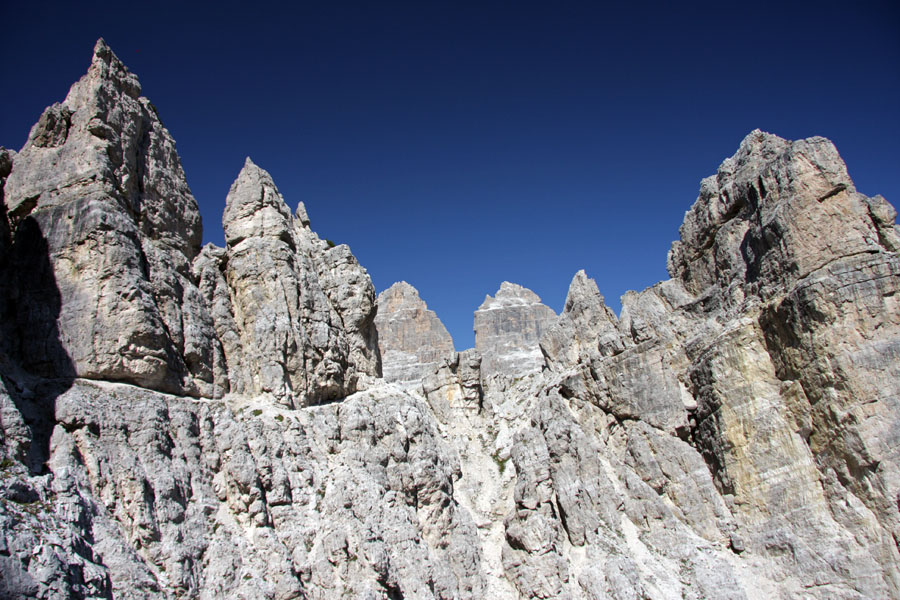 Špice
Po vzhodnem obvozu stene Cima Cadin di Rimbianco se pokaže nešteto špic. Zadaj tudi dve od treh Cin. Pot Bonacossa je tu opremljena z nekaj železja. Še vedno pa je to pot in ne ferata.
Ključne besede: pot bonacossa cadini di misurina tre tri cine cime dolomiti